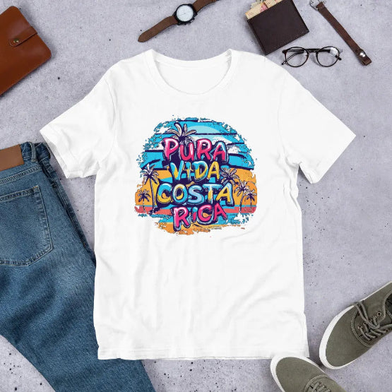 👉 "Unisex t-shirt with a 'Pura Vida CR' design, showcasing Costa Rica’s iconic phrase alongside tropical elements like waves and palm trees."